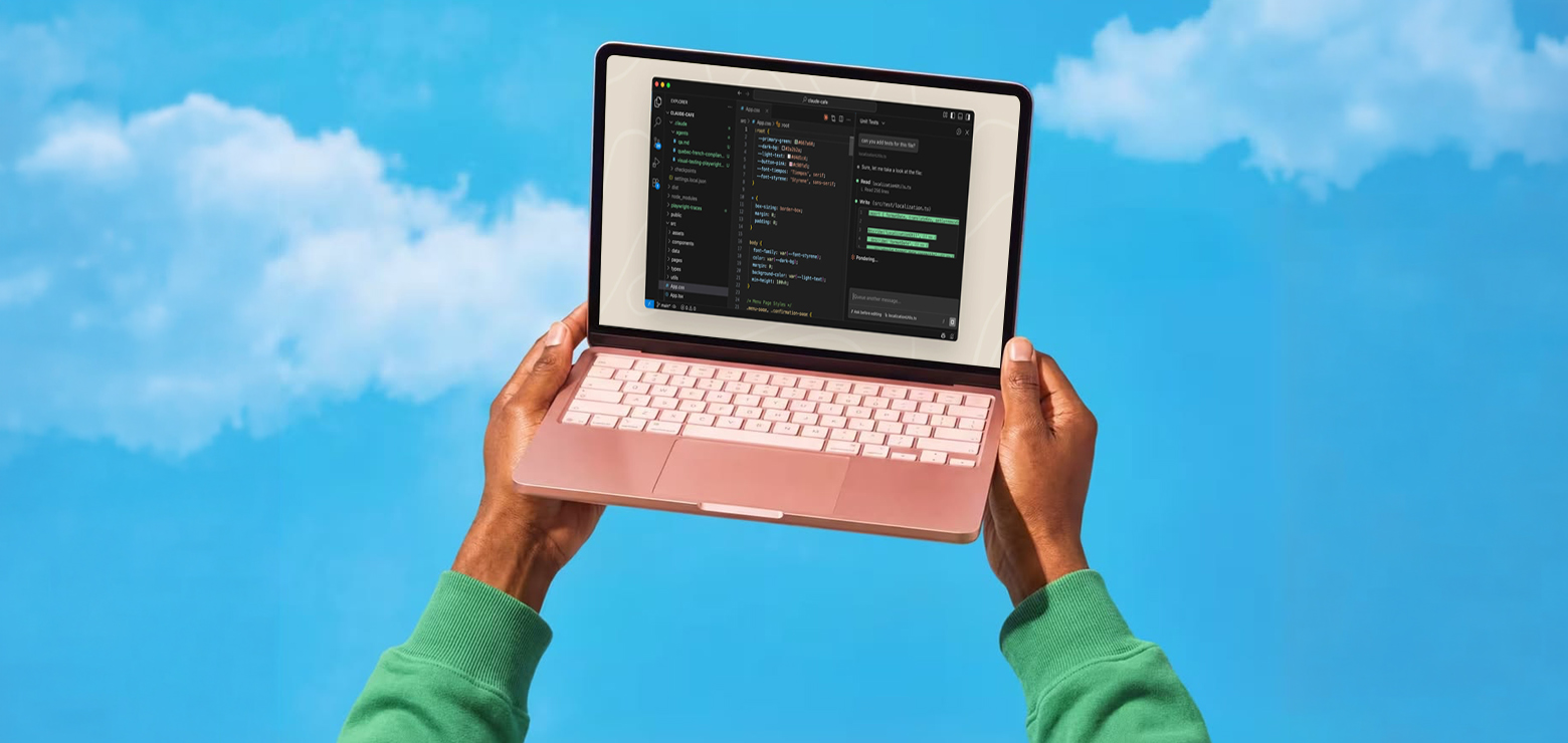 A pair of hands in a bright green sweater holding up a rose gold laptop displaying an integrated development environment with code and an AI chat interface against a bright blue sky with soft white clouds.