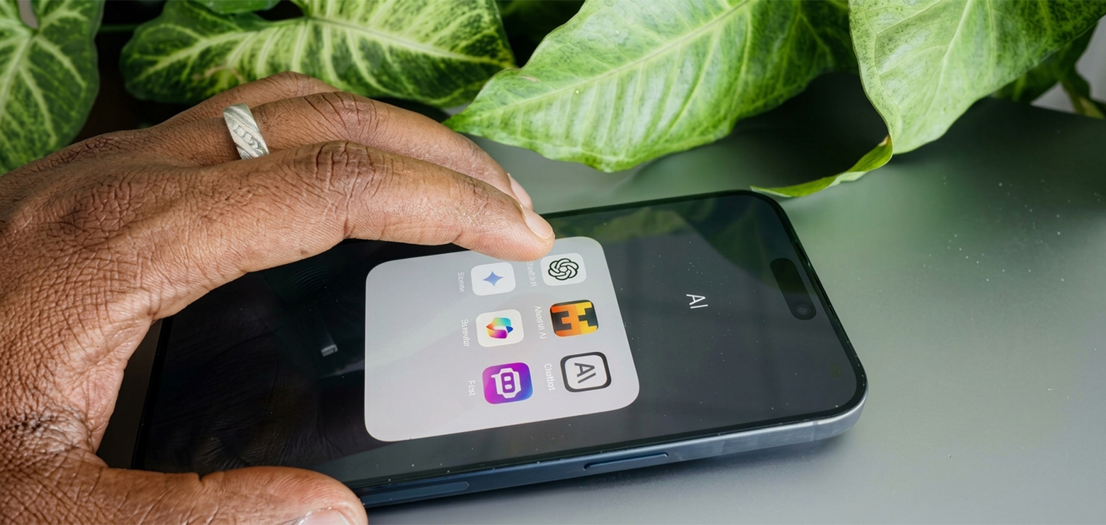 A person's hand with a ring holding a smartphone displaying an AI folder with ChatGPT, Claude, Perplexity, and Gemini app icons on screen, illustrating how a dedicated GEO agency in Orange County drives brand citations across every major AI engine