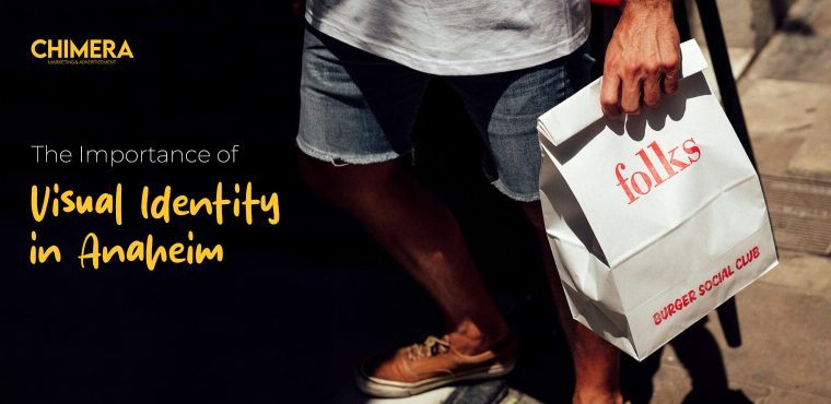 A person walking with a branded Burger Social Club paper bag, which displays the relevance of high visual identity and branding to brands in Anaheim.